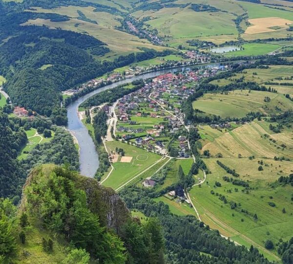 widok ze szczytu, w dole rzeka, miasteczko i pasma górskie
