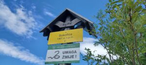 drogowskaz górski:na żółtym napis Sokolica, poniżej "Uwaga żmije"